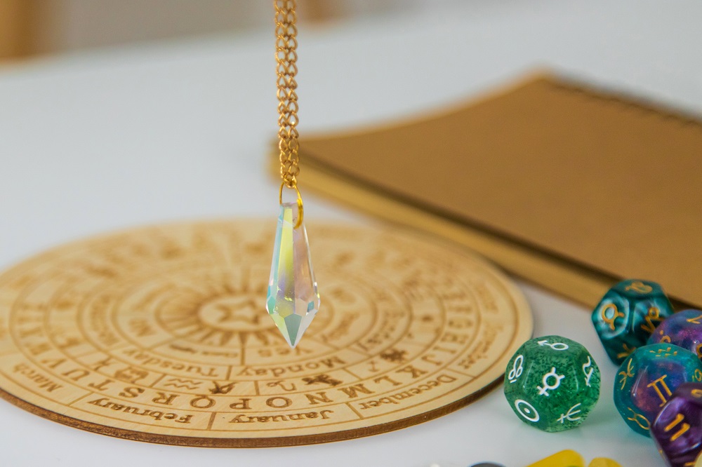 Pendulum numerologist astrologer and zodiac signs. Selective focus.